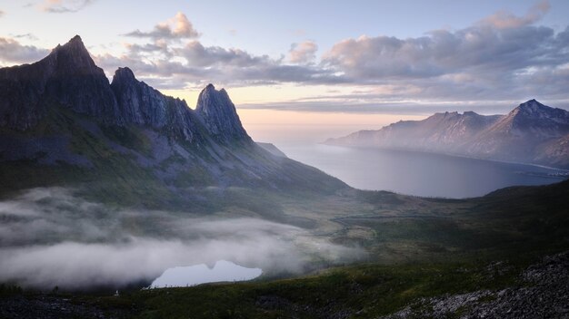 Beautiful scenery of rocky cliffs by the sea under a breathtaking cloudy sky at sunset