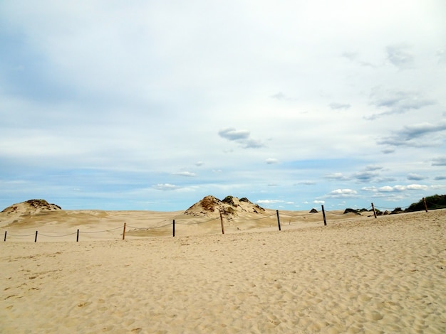 Free photo beautiful scenery of a sandy beach under a cloudy sky in leba, poland