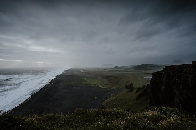 Free photo beautiful scenery of the sea surrounded by rock formations enveloped in fog in iceland