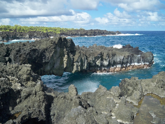 Beautiful scenery of sharp rock formations at the beach under the cloudy sky in Hawaii