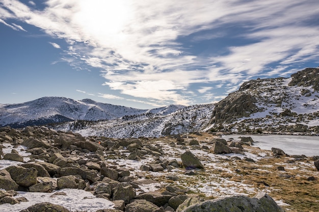 Beautiful scenery of a snow-covered landscape with rocky cliffs under a cloudy sky