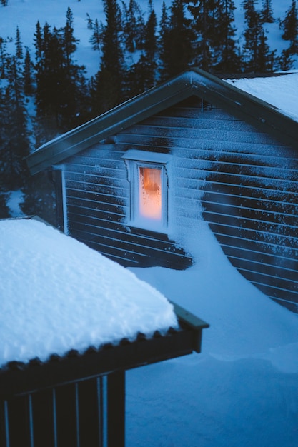 Free Photo beautiful scenery of village with wooden cabins covered with snow surrounded by fir trees in norway