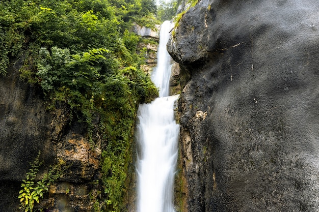 Free photo beautiful scenery of a waterfall flowing through rocky cliffs