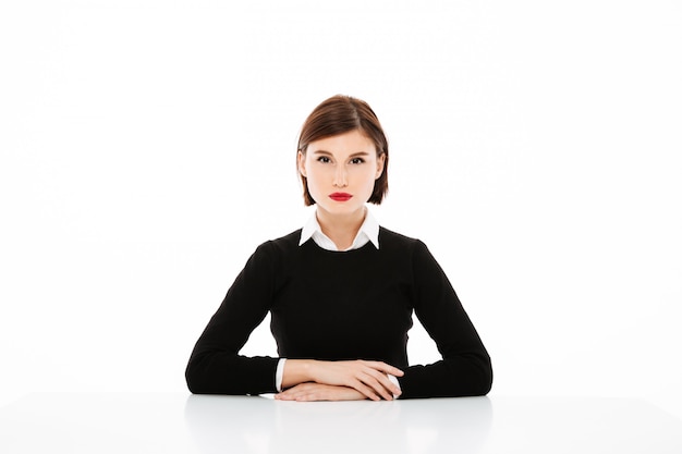 Free photo beautiful serious young business woman sitting at the table, job interview concept