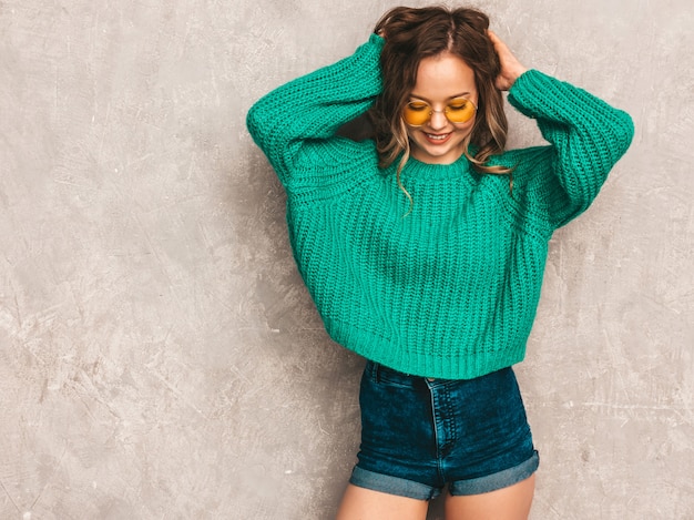 Free Photo beautiful sexy smiling gorgeous girl in green trendy sweater. woman posing in round sunglasses. model having fun