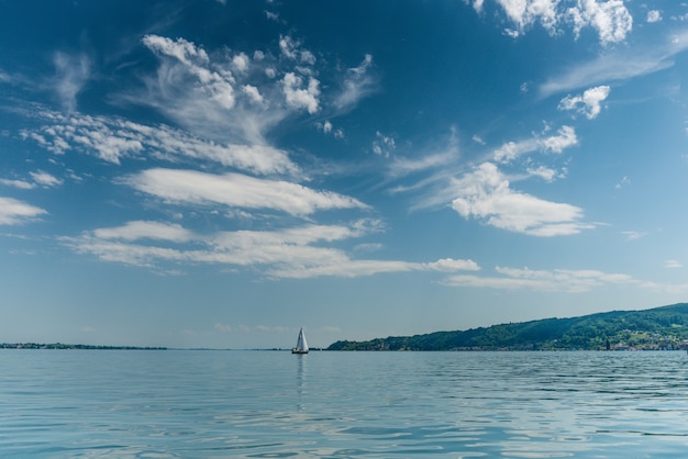 Free Photo beautiful shot of a boat sailing in a calm sea wit hills on the right side