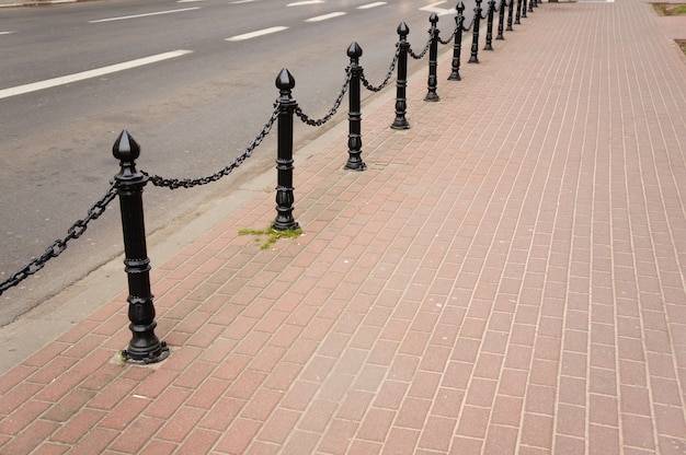 Free photo beautiful shot of a brick sidewalk with black modern security metal poles