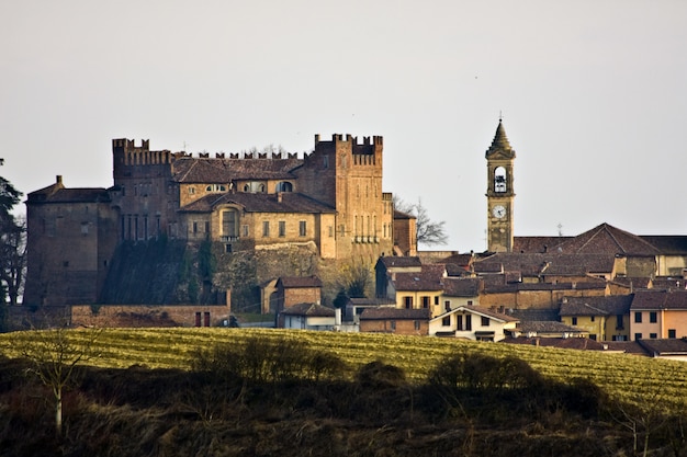 Beautiful shot of buildings with a bell tower in the distance and a white sky