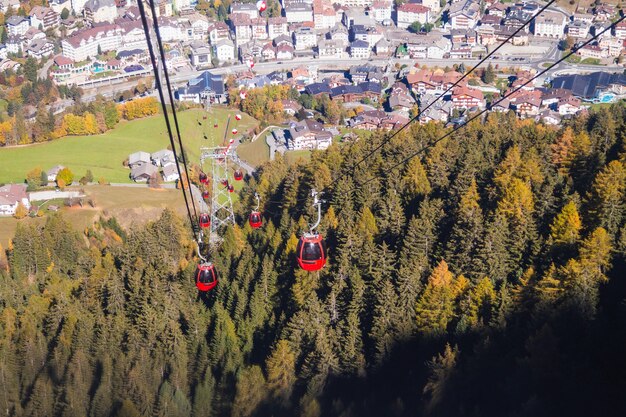 Beautiful shot of cable cars above a forested mountain with buildings in the distance