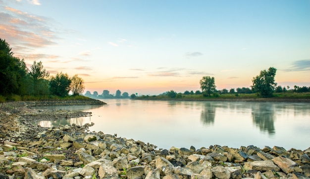 Beautiful shot of a calm lake surrounded by trees during a sunset