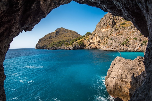 Free Photo beautiful shot of the cliffs near the ocean through the natural stone arch