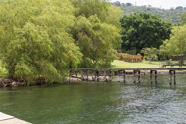 Beautiful shot of coast of the sea with a wooden long pier stretching along to the right