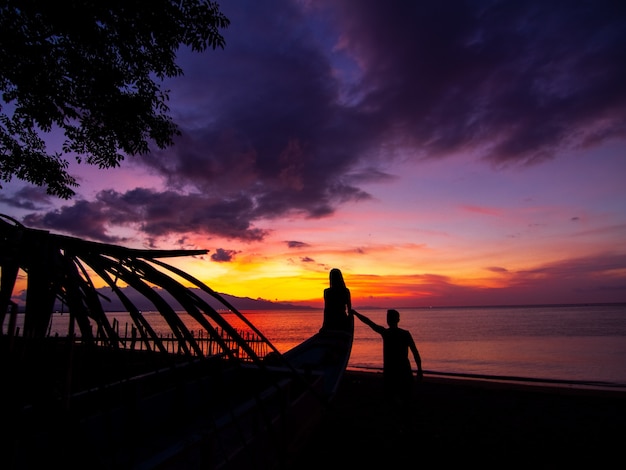 Free photo beautiful shot of a couple on the beach at sunset