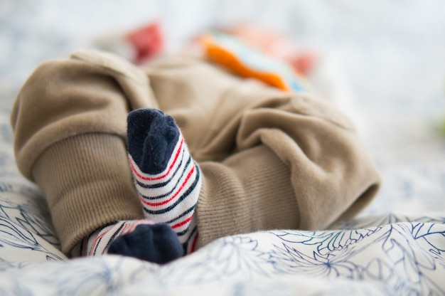 Beautiful shot of the cute little feet of a baby lying on a bed