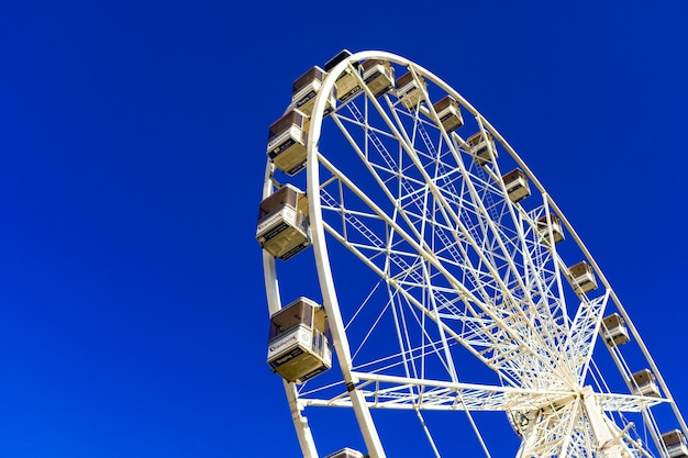 Beautiful shot of a Ferris wheel on the amusement park against the blue sky