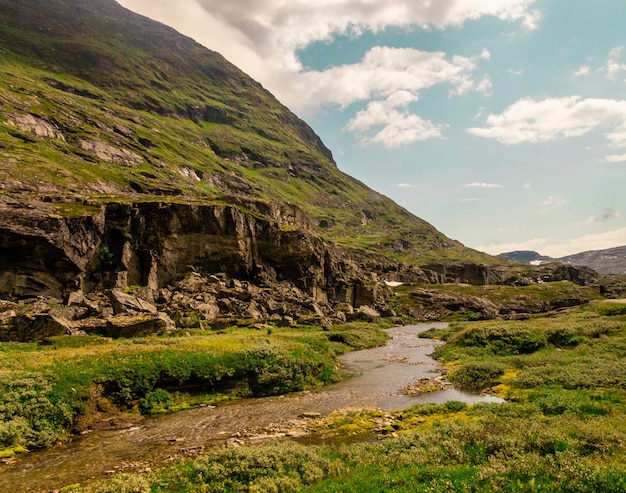 Beautiful shot of a flowing river near high rocky mountains in Norway