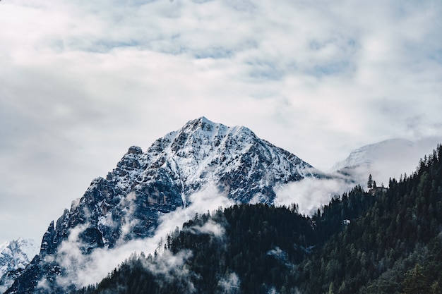 Free photo beautiful shot of foggy and cloudy high rocky mountains