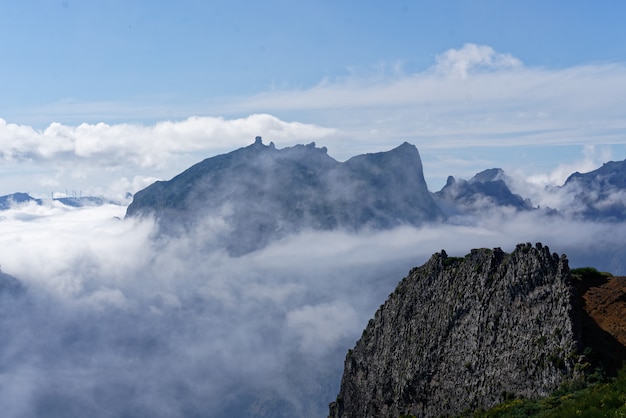 Beautiful shot from the top of the mountain above the clouds with a mountain in the distance