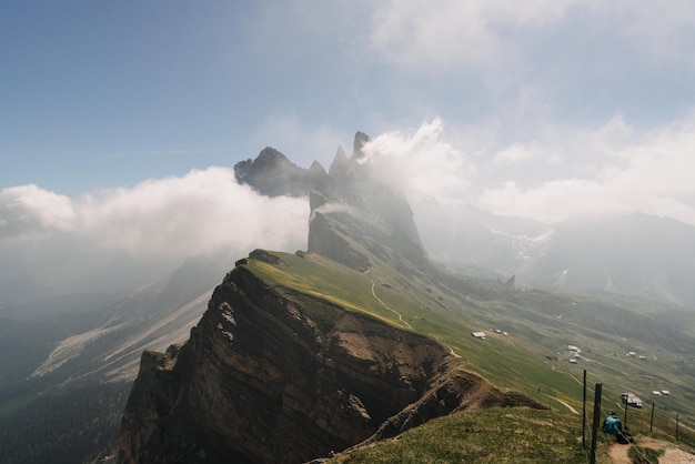 Beautiful shot of green mountains covered with white clouds in a clear blue sky