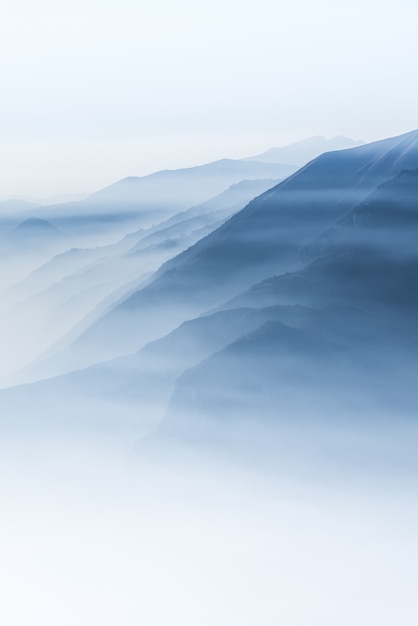 Beautiful shot of high white hilltops and mountains covered in fog