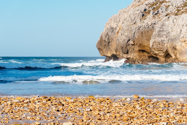 Beautiful shot of the ocean waves crashing on the rocks near the beach