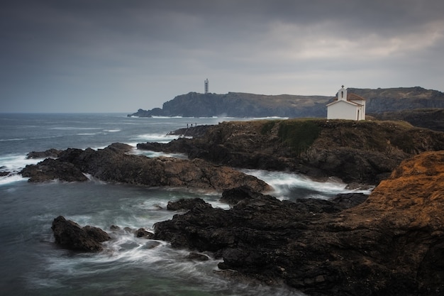 Free photo beautiful shot of the ocean with rock formations by the shore on a cloudy day