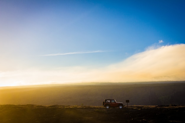 Free photo beautiful shot of an offroad car on a hill with a blue sky in the background at daytime