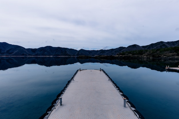 Free Photo beautiful shot of a pathway on the water with mountains in the distance under a cloudy sky