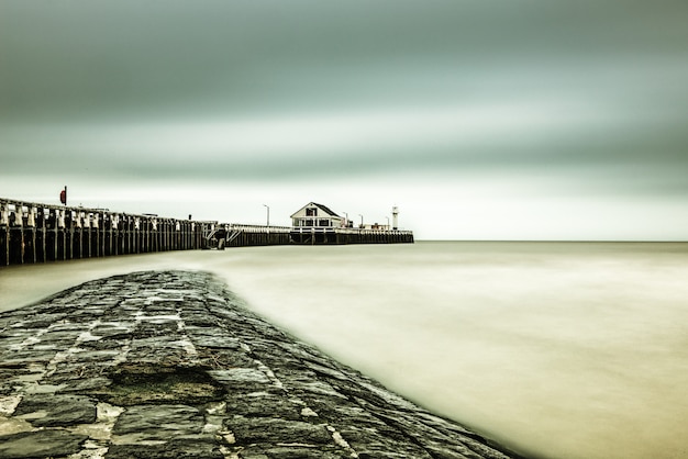 Free Photo beautiful shot of a pier near the sea under the breathtaking sky