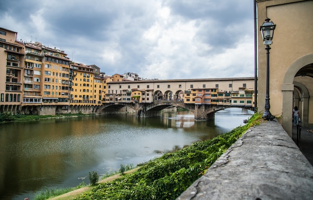 Beautiful shot of Ponte Vecchio in Florence, Italy with a cloudy gray sky in the background