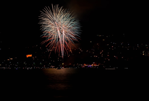 Beautiful shot of red fireworks over a lake in Switzerland at night