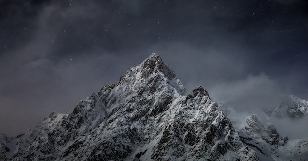 Free photo beautiful shot of rocky mountains covered with white snow