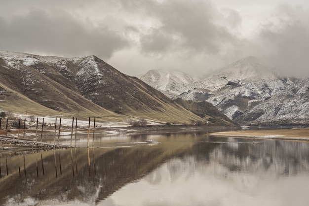 Beautiful shot of the sea reflecting the mountains under a cloudy sky