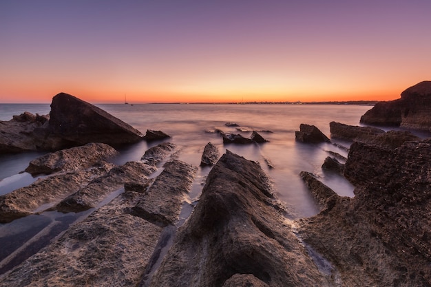 Free photo beautiful shot of the sea with cliffs and rocks during sunset