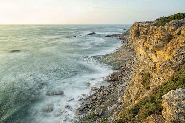 Beautiful shot of a seashore with scenery of sunset in a clear sky