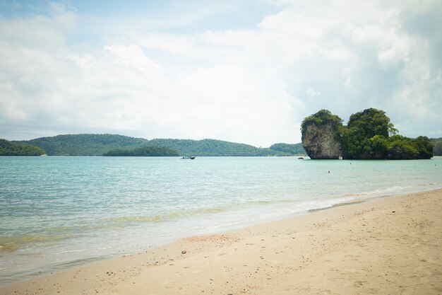 Beautiful shot of the shore with rocks in the water and mountains in the distance