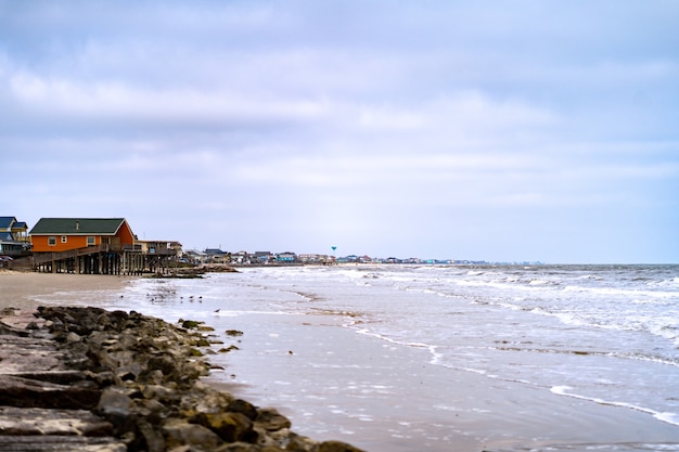 Free Photo beautiful shot of the shoreline and a wooden house in the distance