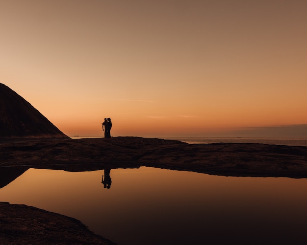 Free Photo beautiful shot of silhouettes of people on a beach during sunrise