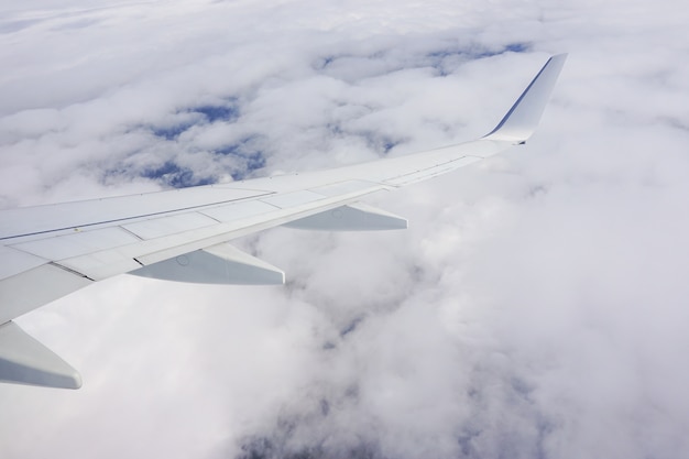 Free photo beautiful shot of the sky full of clouds and an airplane wing from the plane window