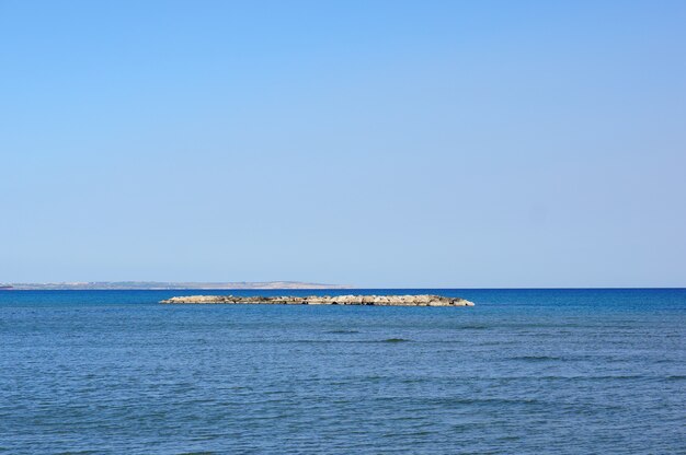 Beautiful shot of a small island covered in rocks in the middle of a lake