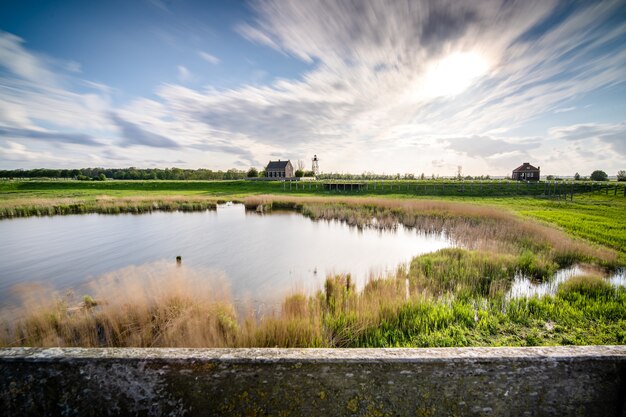 Beautiful shot of a small lake surrounded by greenery under a cloudy sky