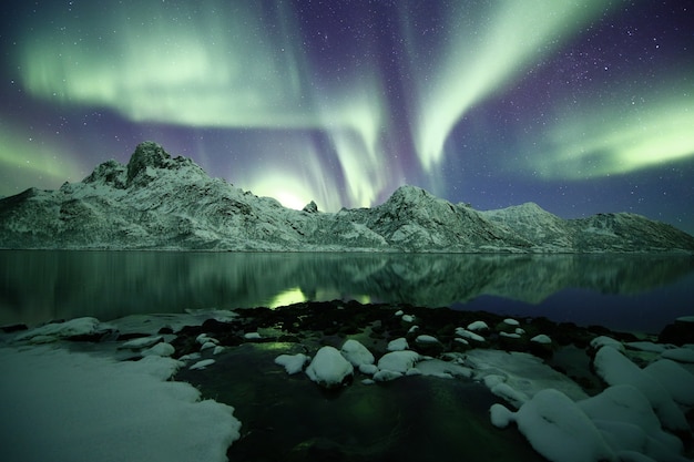 A beautiful shot of snowy mountains under a polar light