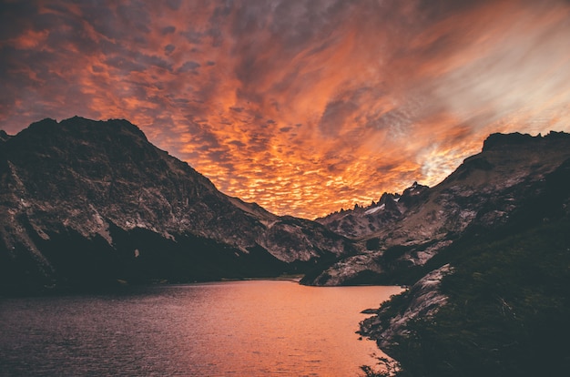 Beautiful shot of the sunset in the mountains by the lake with amazing clouds