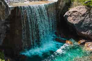 Free photo beautiful shot of a waterfall near huge rock formations in pragelato, italy