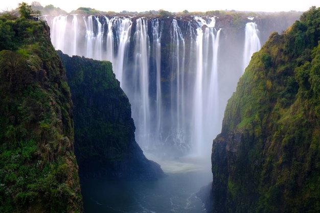 Beautiful shot of a waterfall surrounded by trees and hills