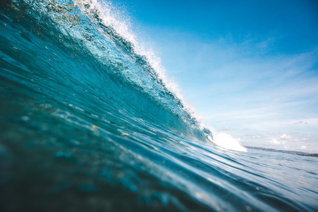 Beautiful shot of a wave taking shape under the clear blue sky captured in Lombok, Indonesia