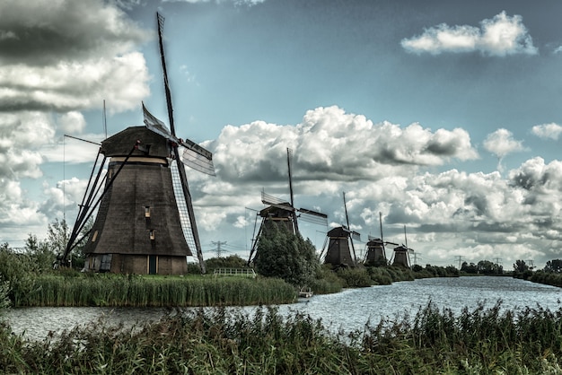 Beautiful shot of windmills reflected in the lake under the breathtaking cloudy sky