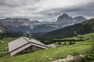 Free photo beautiful shot of a wooden house in the green valley puez-geisler nature park in miscì, italy