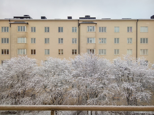 Free Photo beautiful shot of yellow building and trees covered with snow during the winter