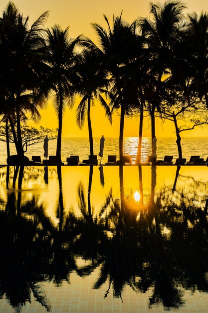 Beautiful Silhouette coconut palm tree on sky around swimming pool in hotel resort neary sea ocean b